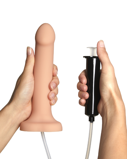 Hands holding a Lovely Planet Strap-On-Me 5.7 Inch Silicone Squirting Cum Dildo - Vanilla with a pump mechanism against a white background.
