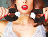 A woman with bold red lipstick holding up a pair of Blush Temptasia Furry Cuffs Handcuffs in various colors, only her lower face and hands visible, suggesting a theme of playful role play.